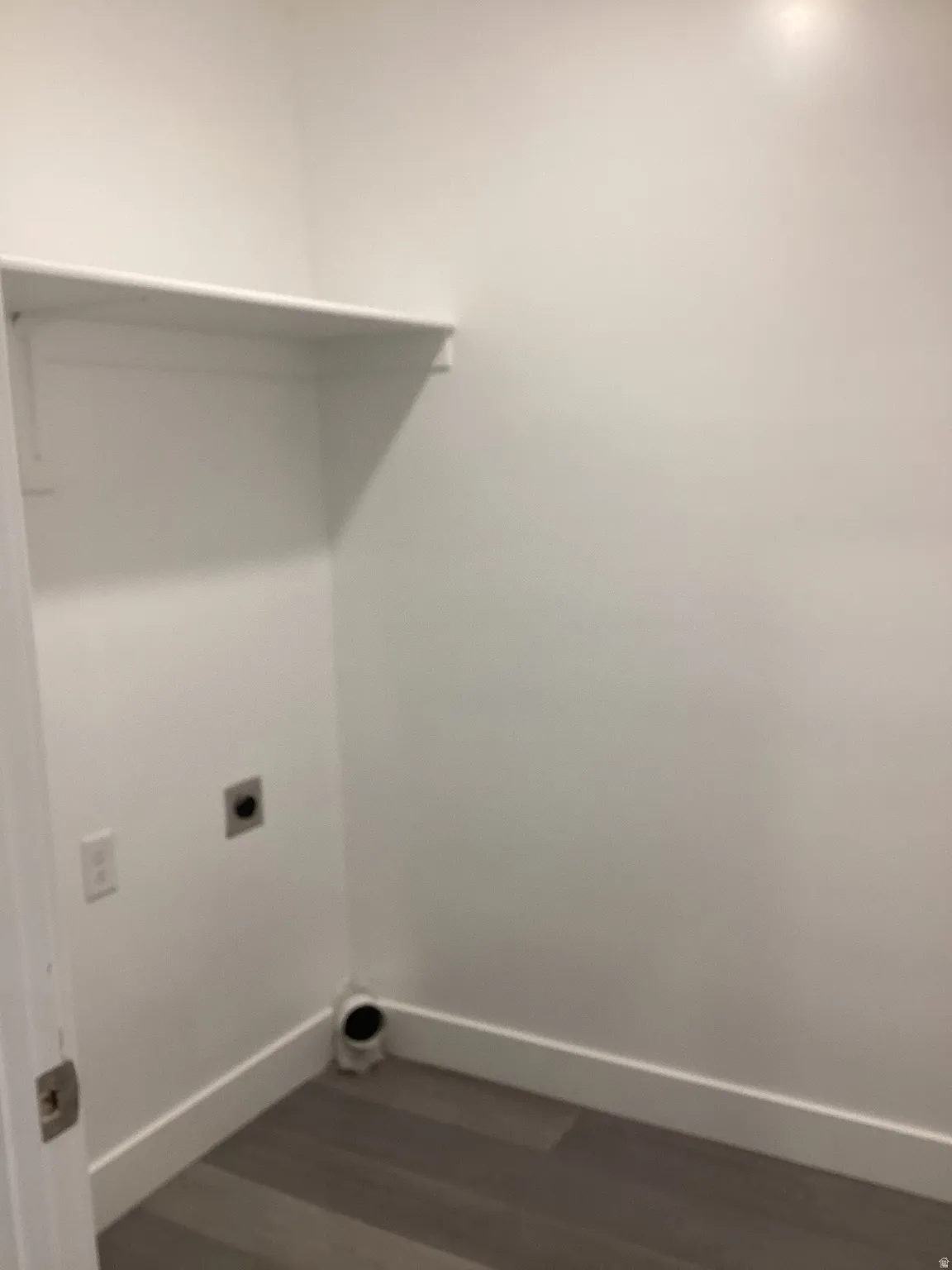 Laundry area featuring dark wood-type flooring and electric dryer hookup