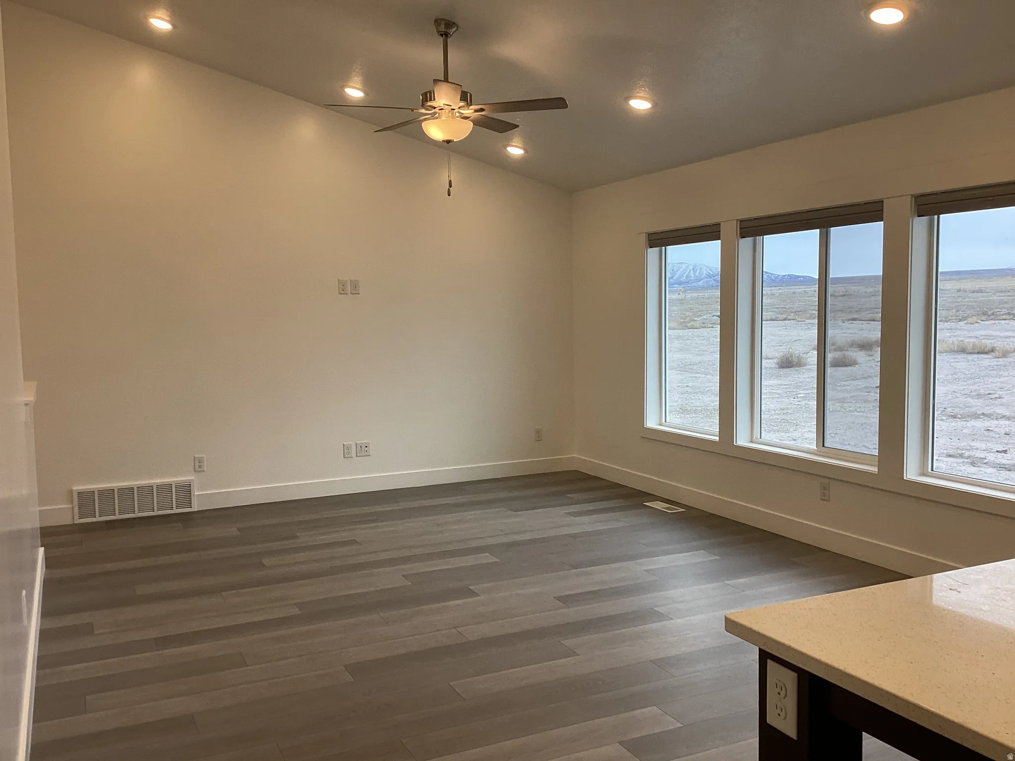 Spare room with recessed lighting, a ceiling fan, dark wood-style floors, a mountain view, and lofted ceiling