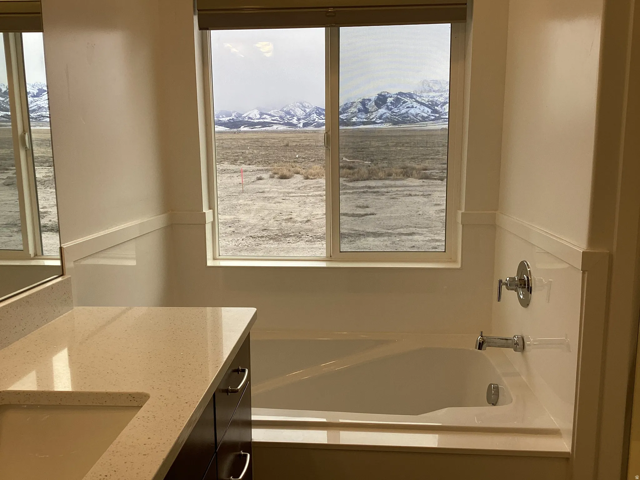 Bathroom featuring a mountain view, vanity, and a bath