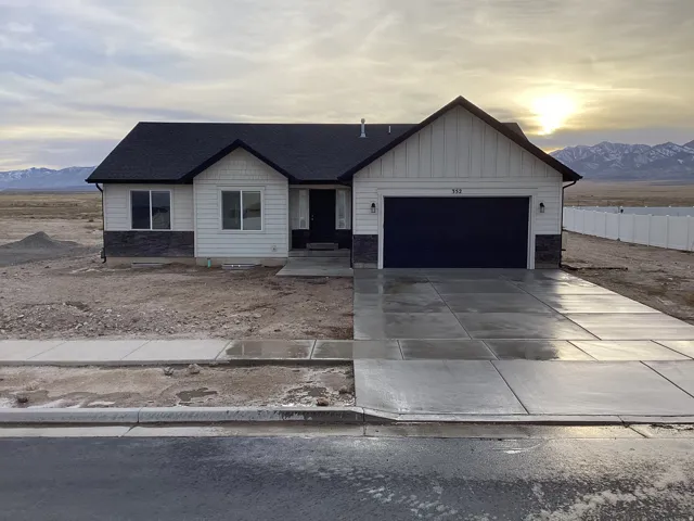 View of front of property with a mountain view, board and batten siding, an attached garage, driveway, and roof with shingles