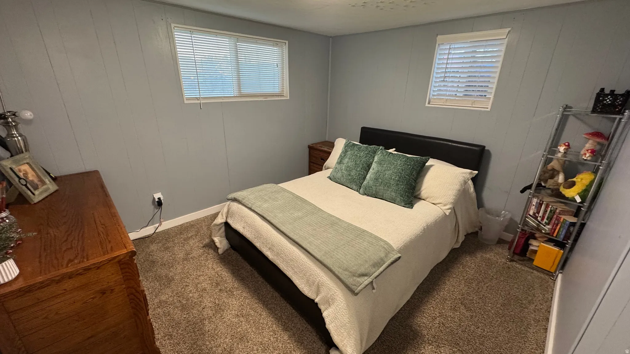 Carpeted bedroom with wooden walls and baseboards
