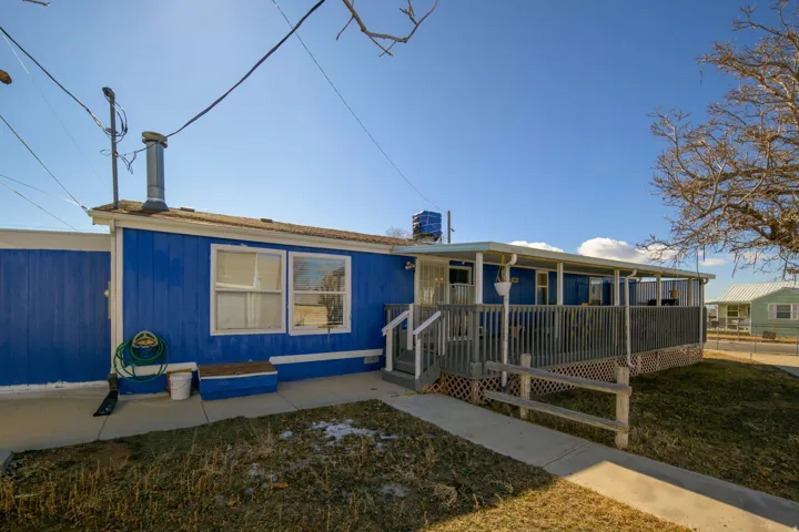 View of front of house featuring a chimney, a wooden deck, and a front yard