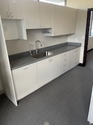 Kitchen featuring white cabinets and dark countertops