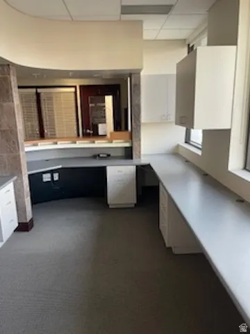 Bathroom with a paneled ceiling, vanity, and dark colored carpet