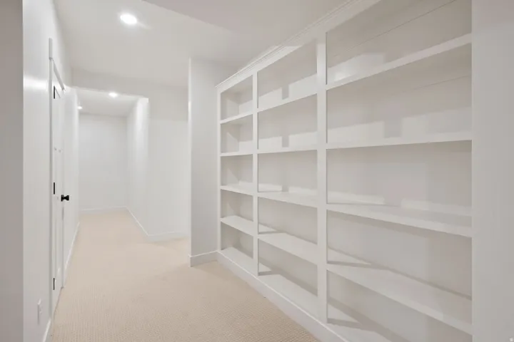 Hallway with light colored carpet and recessed lighting