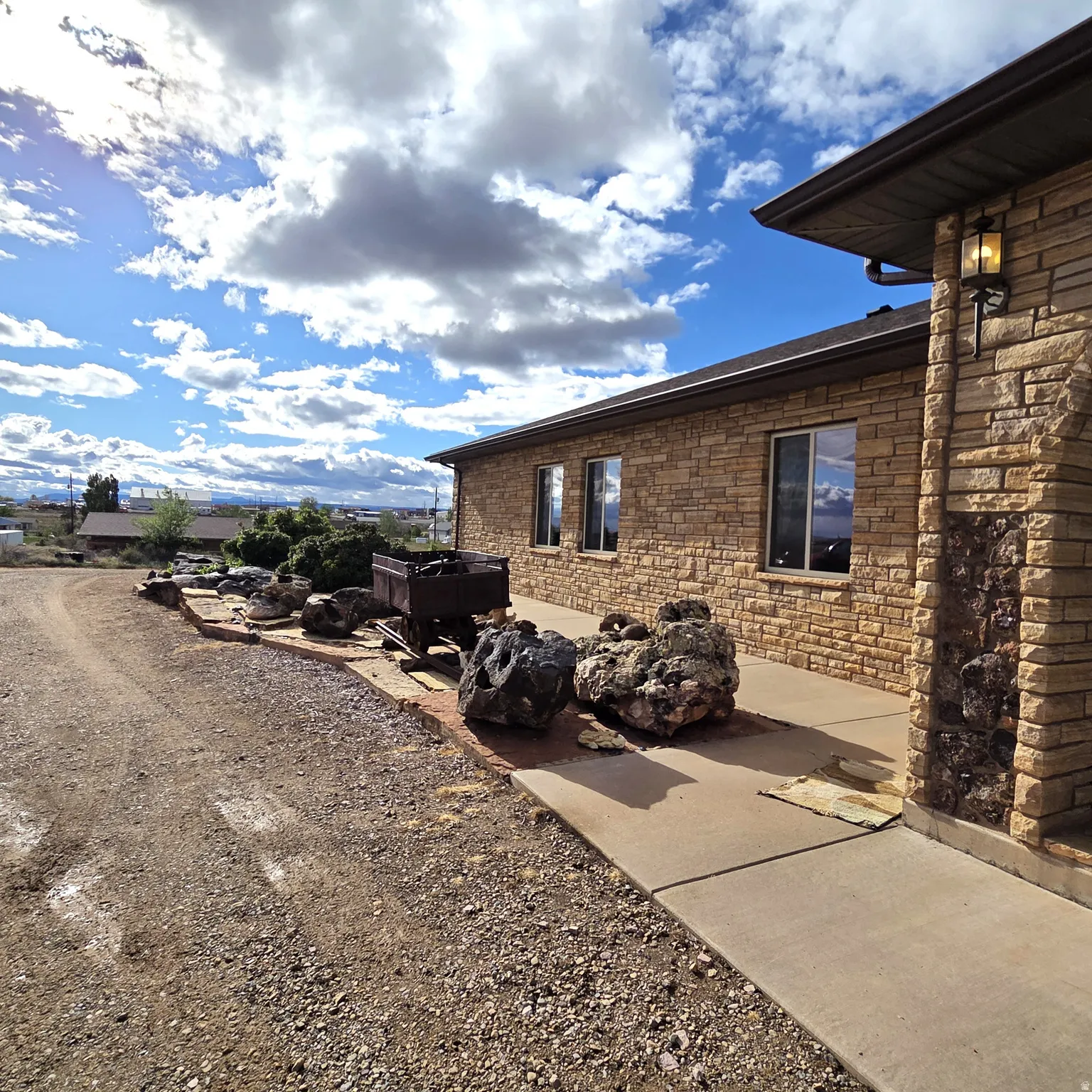 View of home's exterior featuring stone siding and a patio area