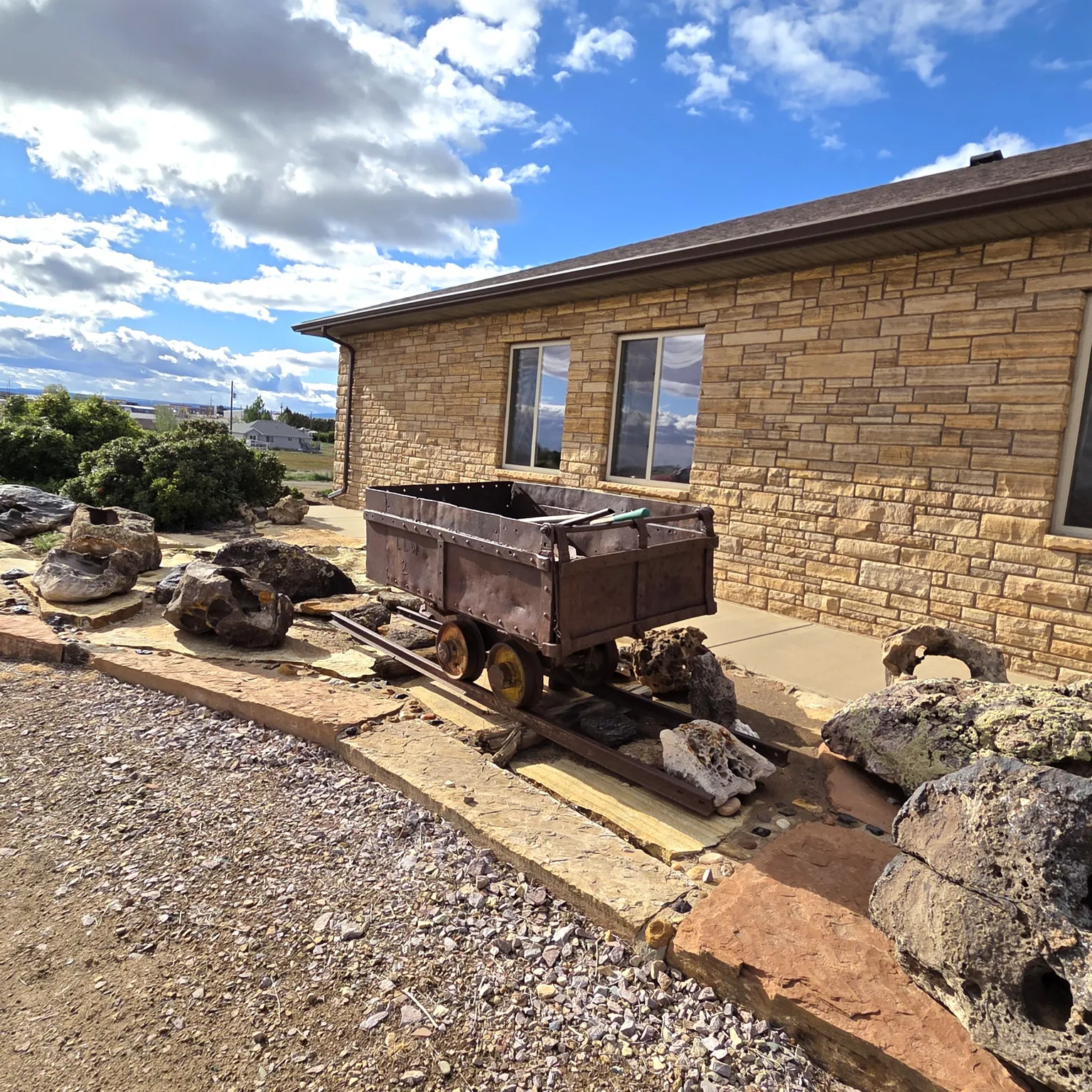 View of property exterior featuring stone siding and a patio