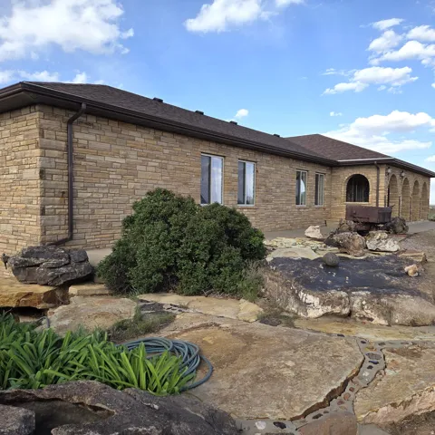 Back of property featuring roof with shingles and a patio area
