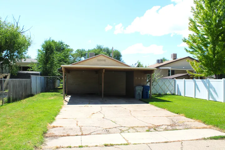 Carport structure with a brick exterior and built in storage shed.