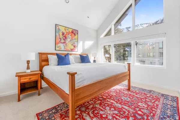 Bedroom with high vaulted ceiling and ensuite bull bath with steam shower