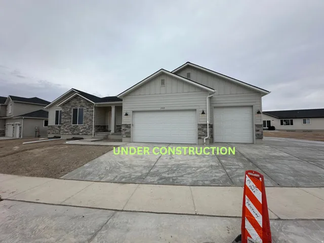 View of front of house with stone siding, board and batten siding, and concrete driveway