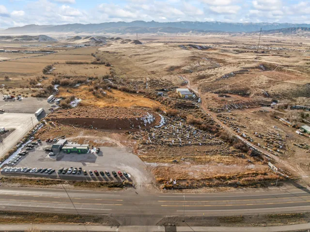 Aerial view of property and surrounding area featuring a mountainous background and rural landscape