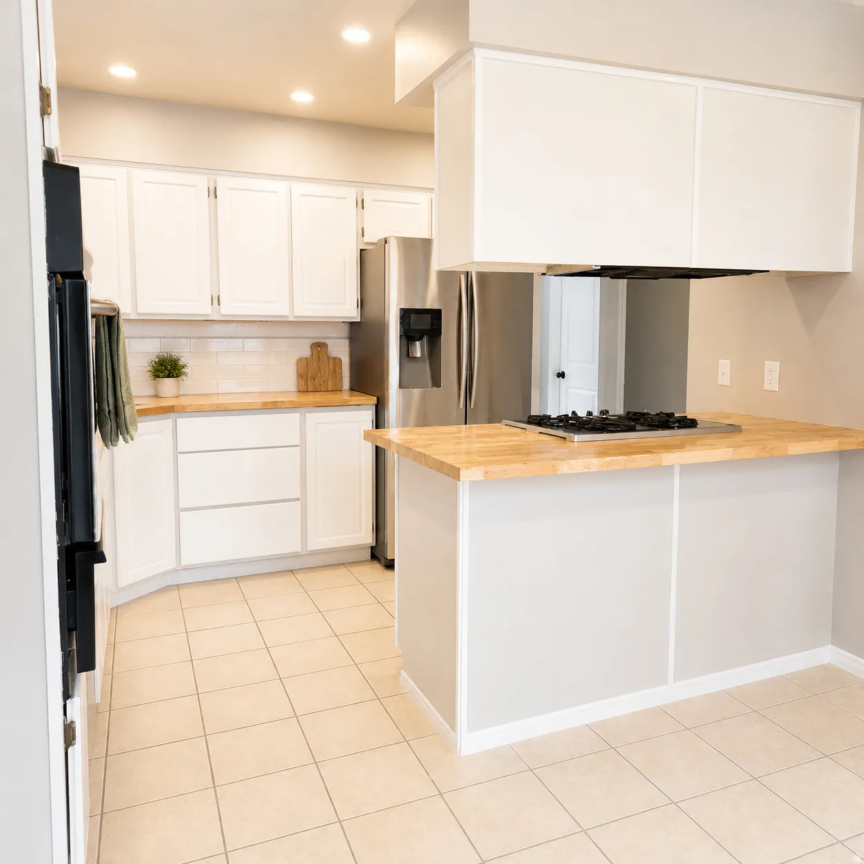 Kitchen featuring light wood-finish countertops, white cabinetry, and stainless steel appliances