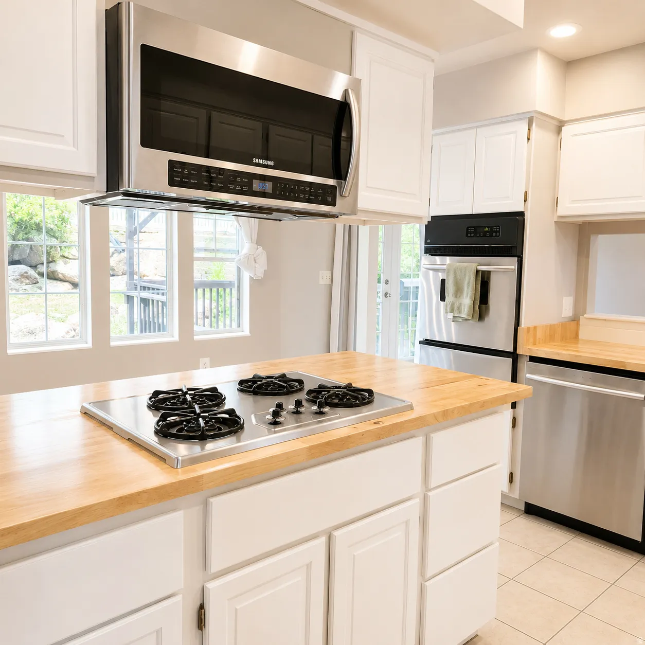 Kitchen island with a built-in stainless steel gas cooktop and wood-finish countertop