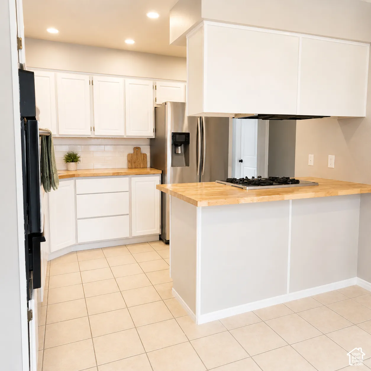 Kitchen featuring light wood-finish countertops, white cabinetry, and stainless steel appliances