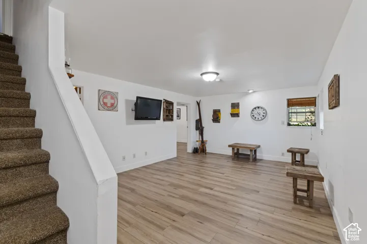 Living area featuring stairway and light wood-style flooring