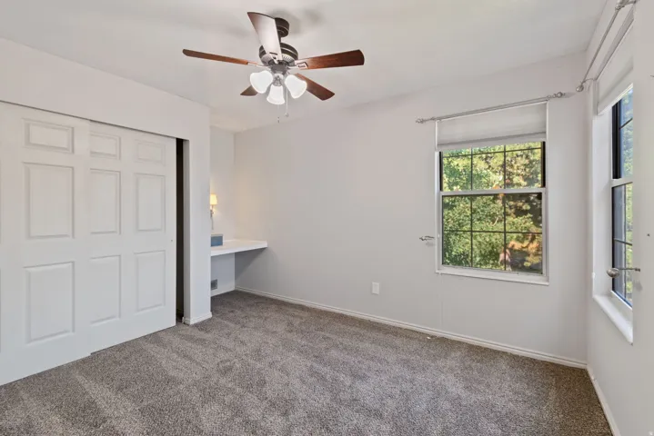Unfurnished bedroom with carpet floors, a closet, and a ceiling fan