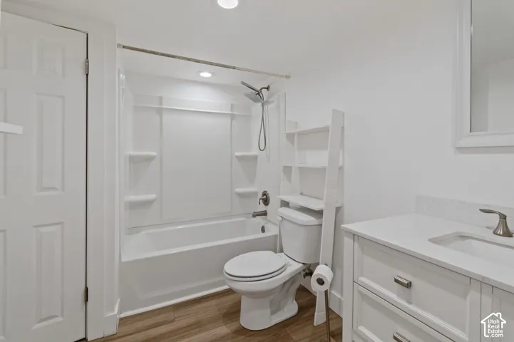 Full bath with vanity, shower / tub combination, light wood-style floors, and recessed lighting