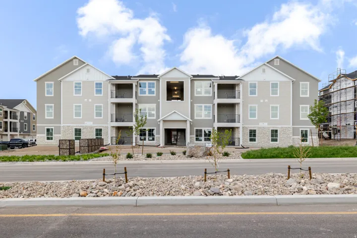 Contemporary multi-story building featuring light grey siding and white trim