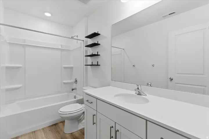 Full bathroom with vanity, light wood-type flooring, and bathtub / shower combination