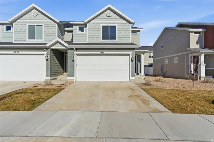 View of front of home with concrete driveway and an attached garage