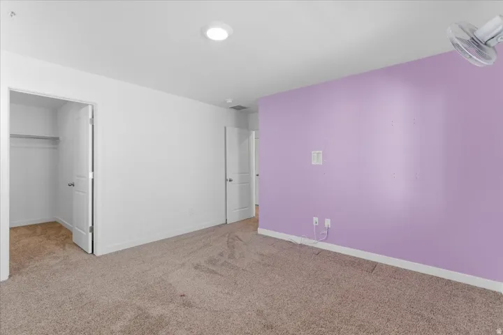 Bedroom featuring a spacious closet and light colored carpet