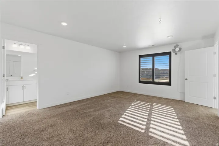 Bedroom featuring light colored carpet and recessed lighting