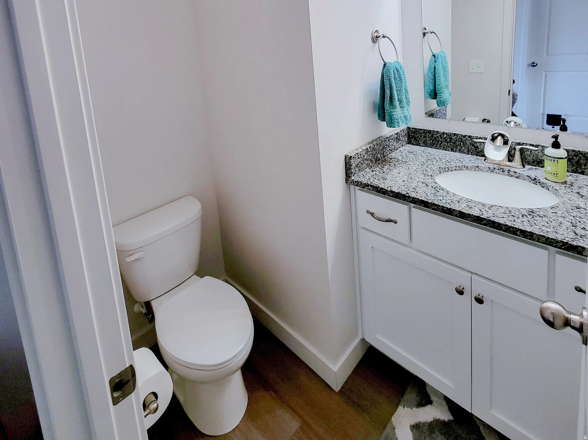 Bathroom with dark wood-style flooring, vanity, and a textured ceiling