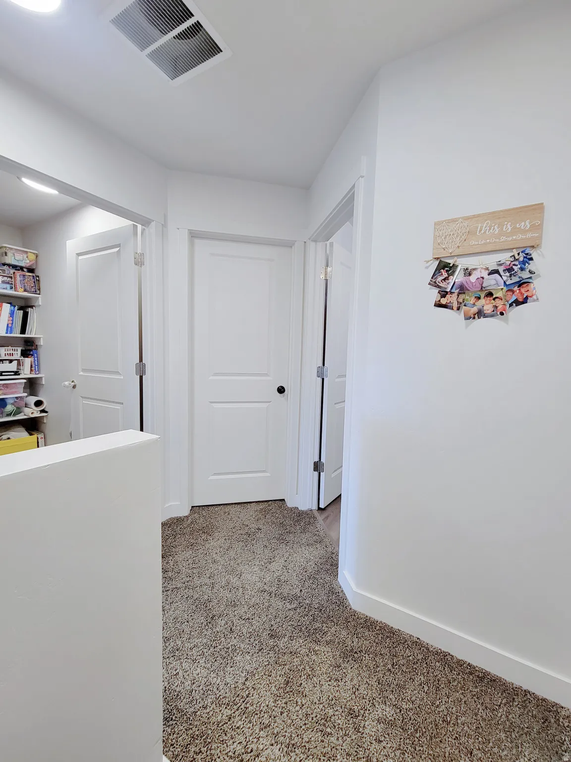 Hallway with carpet flooring and baseboards