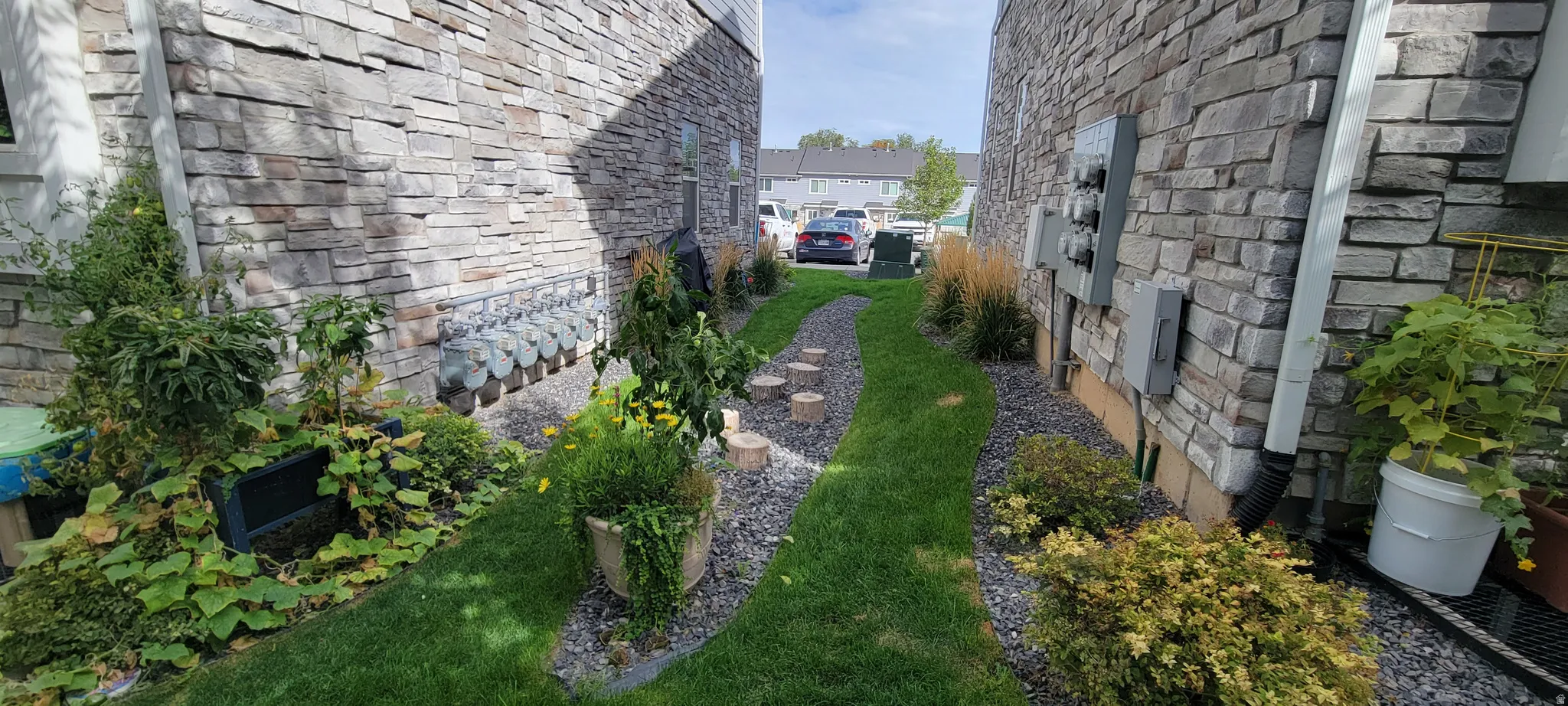 View of property's exterior with extra side yard (end unit) and  stone siding