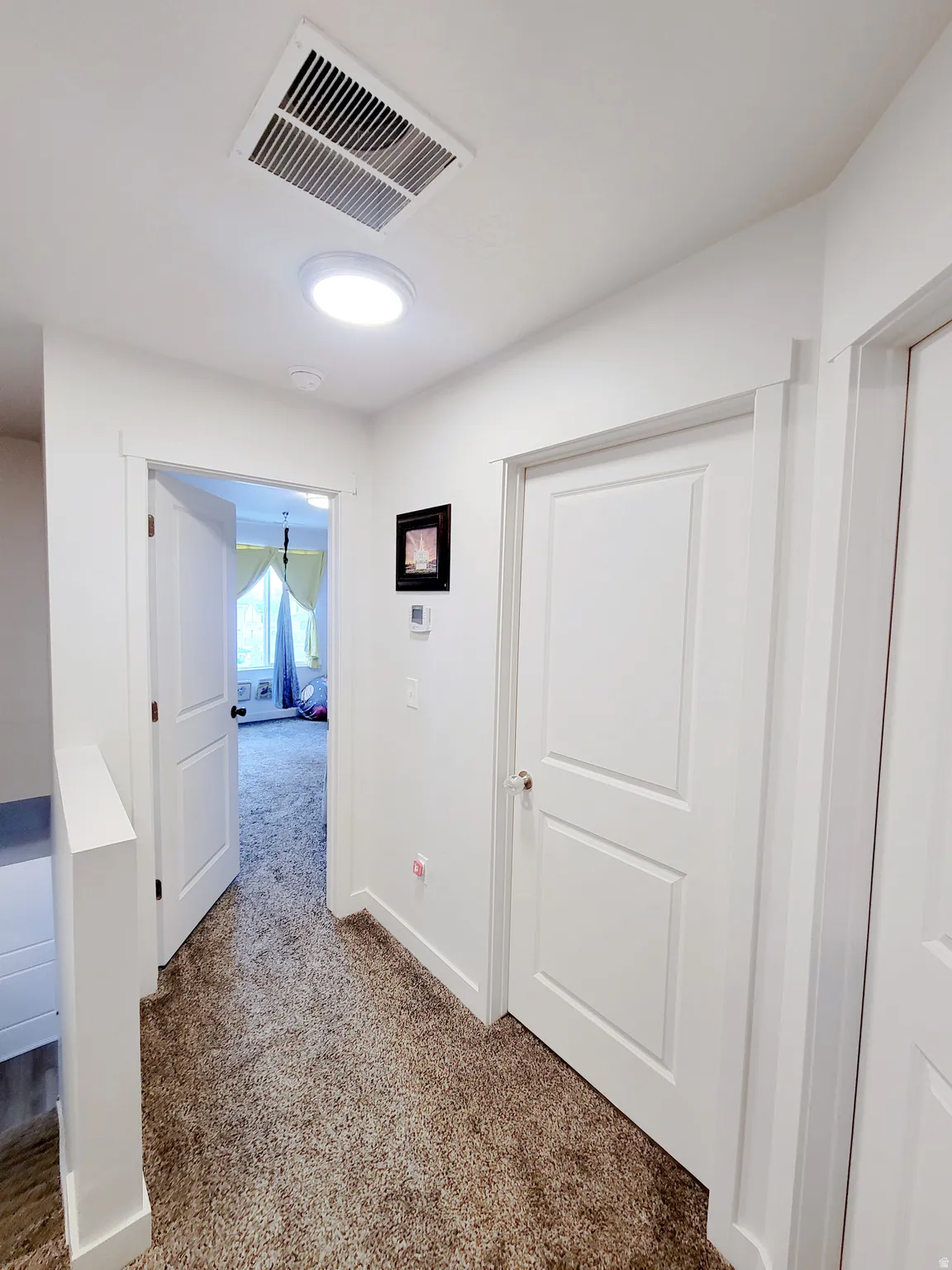 Hallway with carpet flooring and baseboards