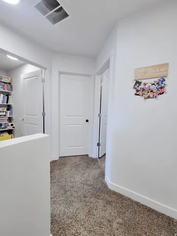 Hallway with carpet flooring and baseboards