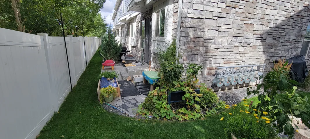 View of partially fenced backyard and a patio