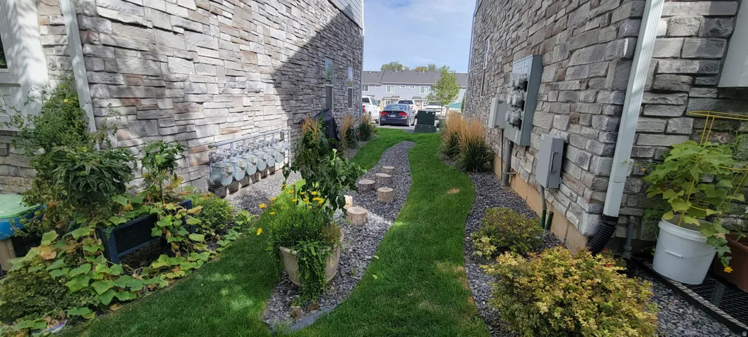 View of property's exterior with extra side yard (end unit) and  stone siding