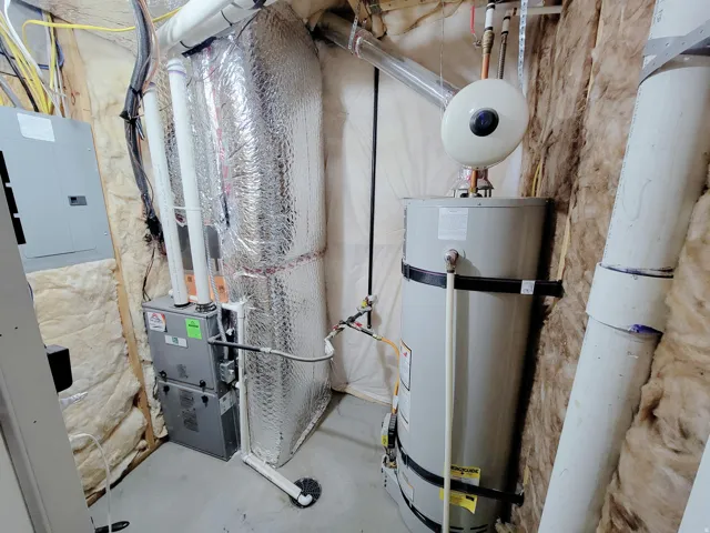 Utilities featuring water heater, heating unit, and electric panel