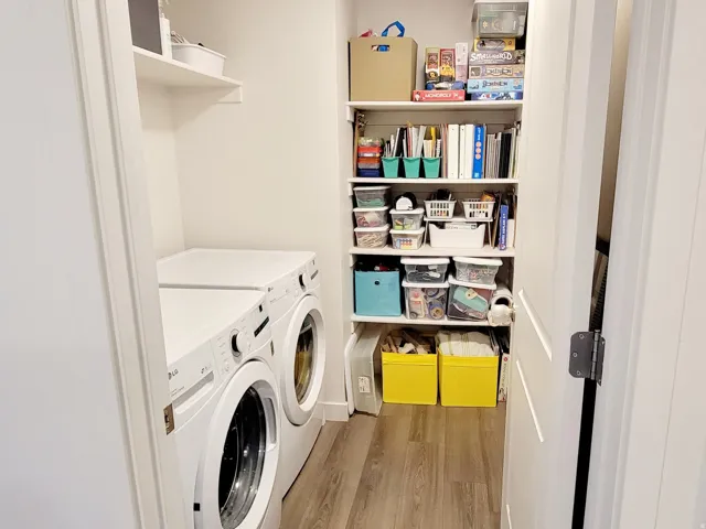 Laundry room with washer and dryer and light wood-type flooring