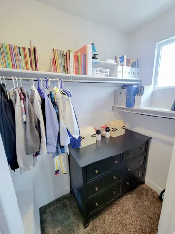 Walk in closet featuring dark colored carpet