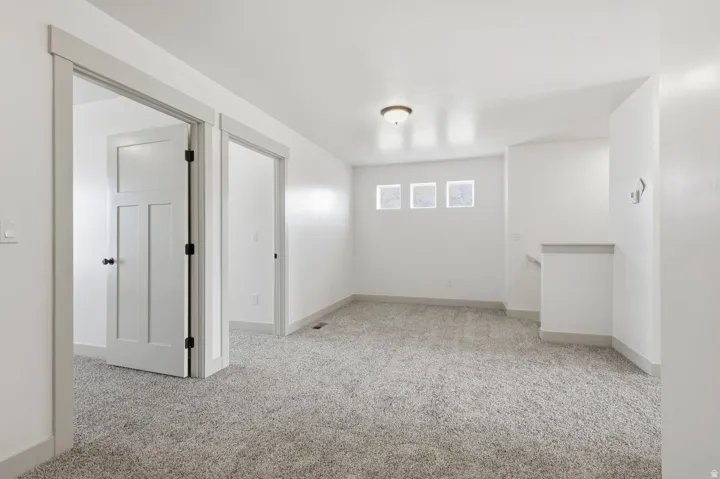 Basement with light colored carpet and baseboards