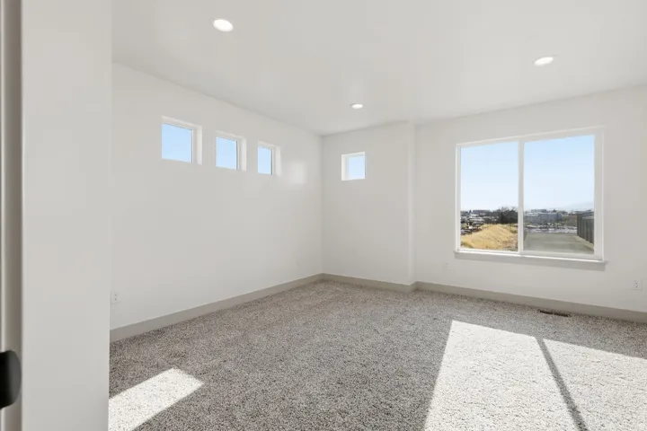 Unfurnished room with light colored carpet and recessed lighting