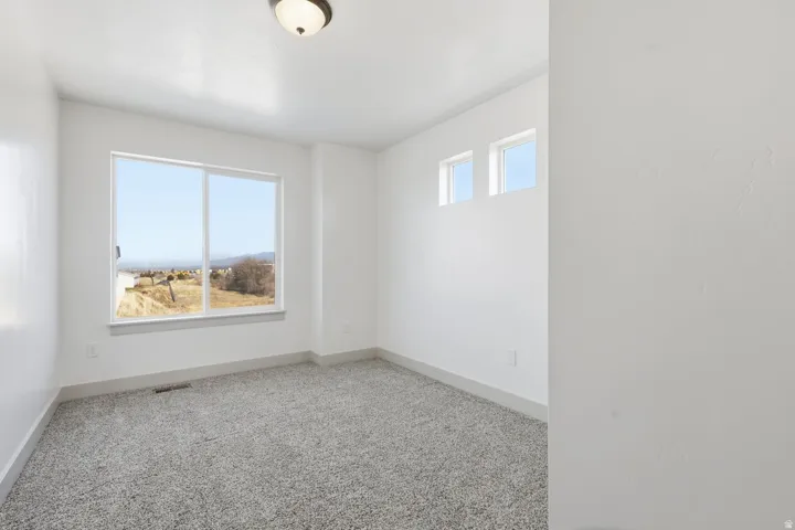 Carpeted spare room featuring baseboards