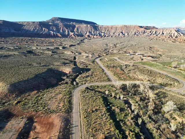 Aerial view of property and surrounding area featuring a mountainous background and rural landscape