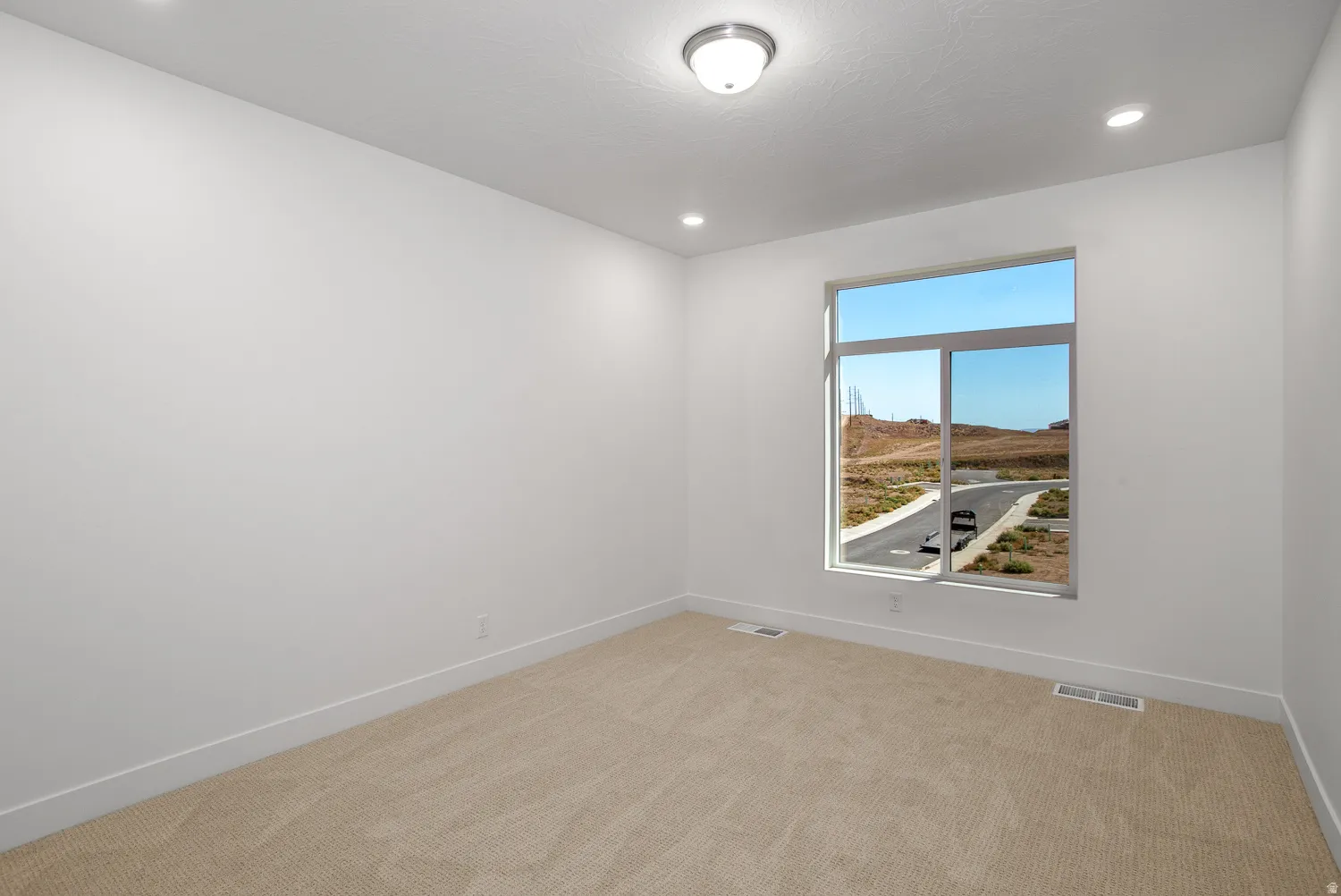 Unfurnished room with light colored carpet and recessed lighting