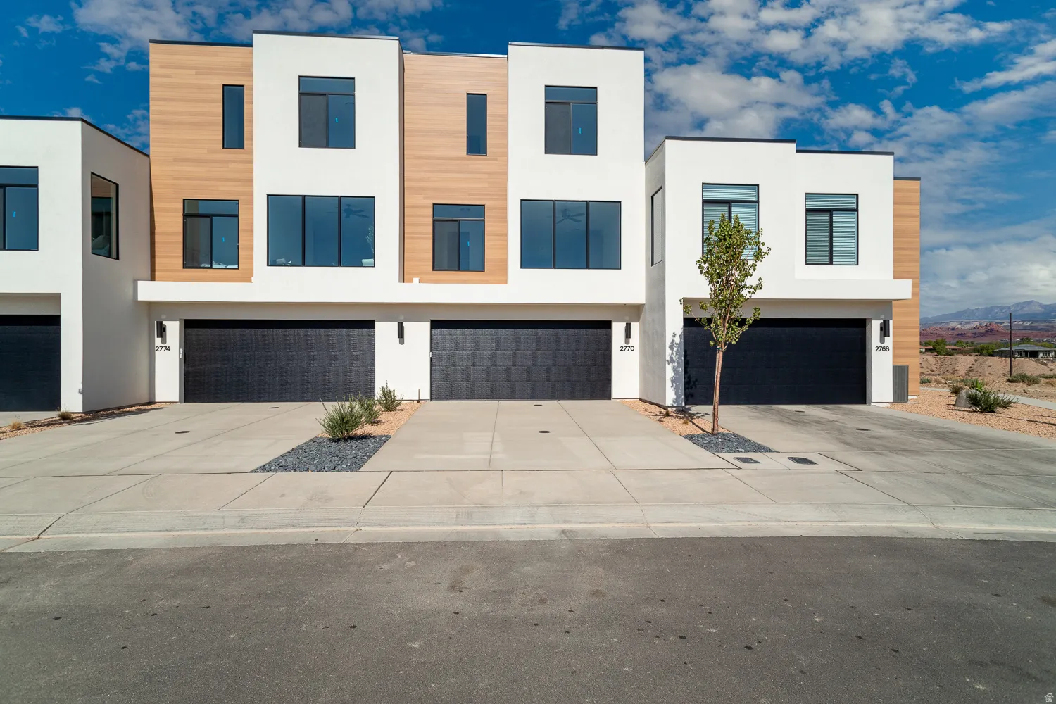 Contemporary house with stucco siding, concrete driveway, and an attached garage
