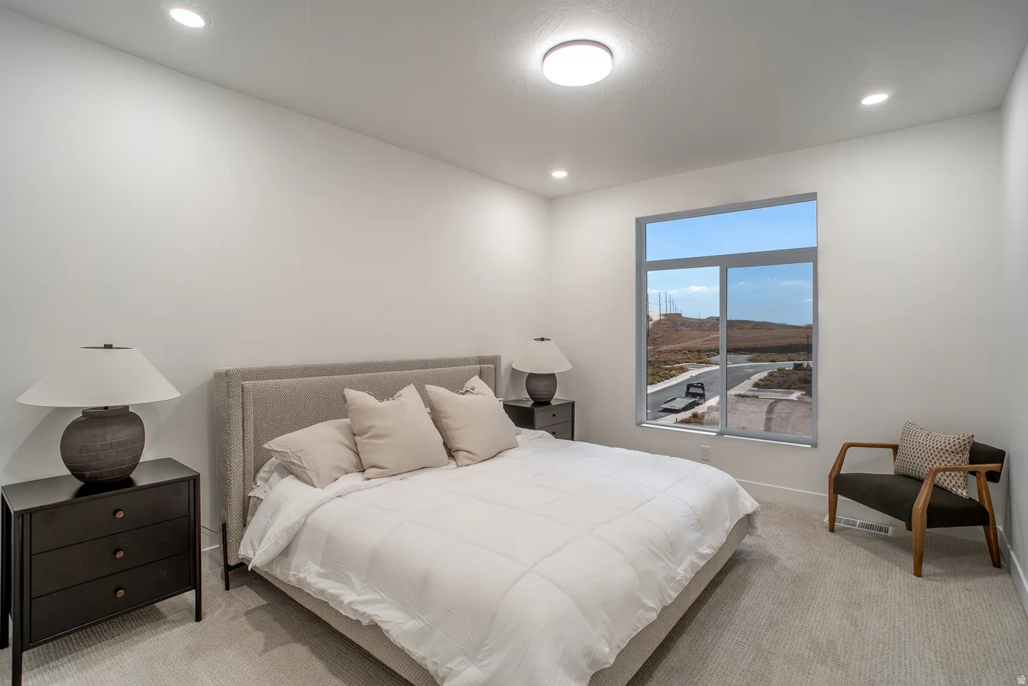Bedroom featuring light colored carpet, recessed lighting, and a mountain view
