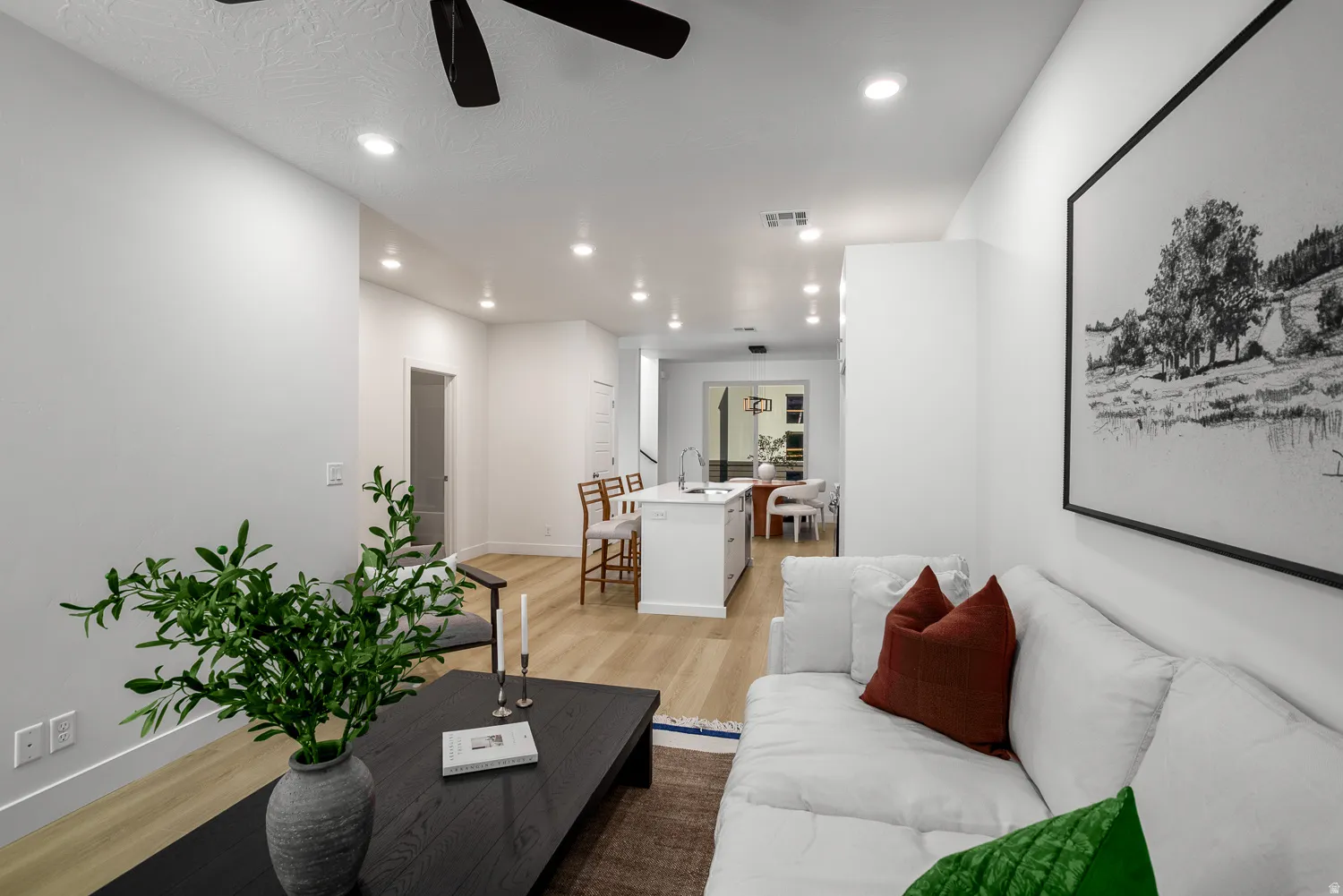 Living area with light wood finished floors, a ceiling fan, and recessed lighting