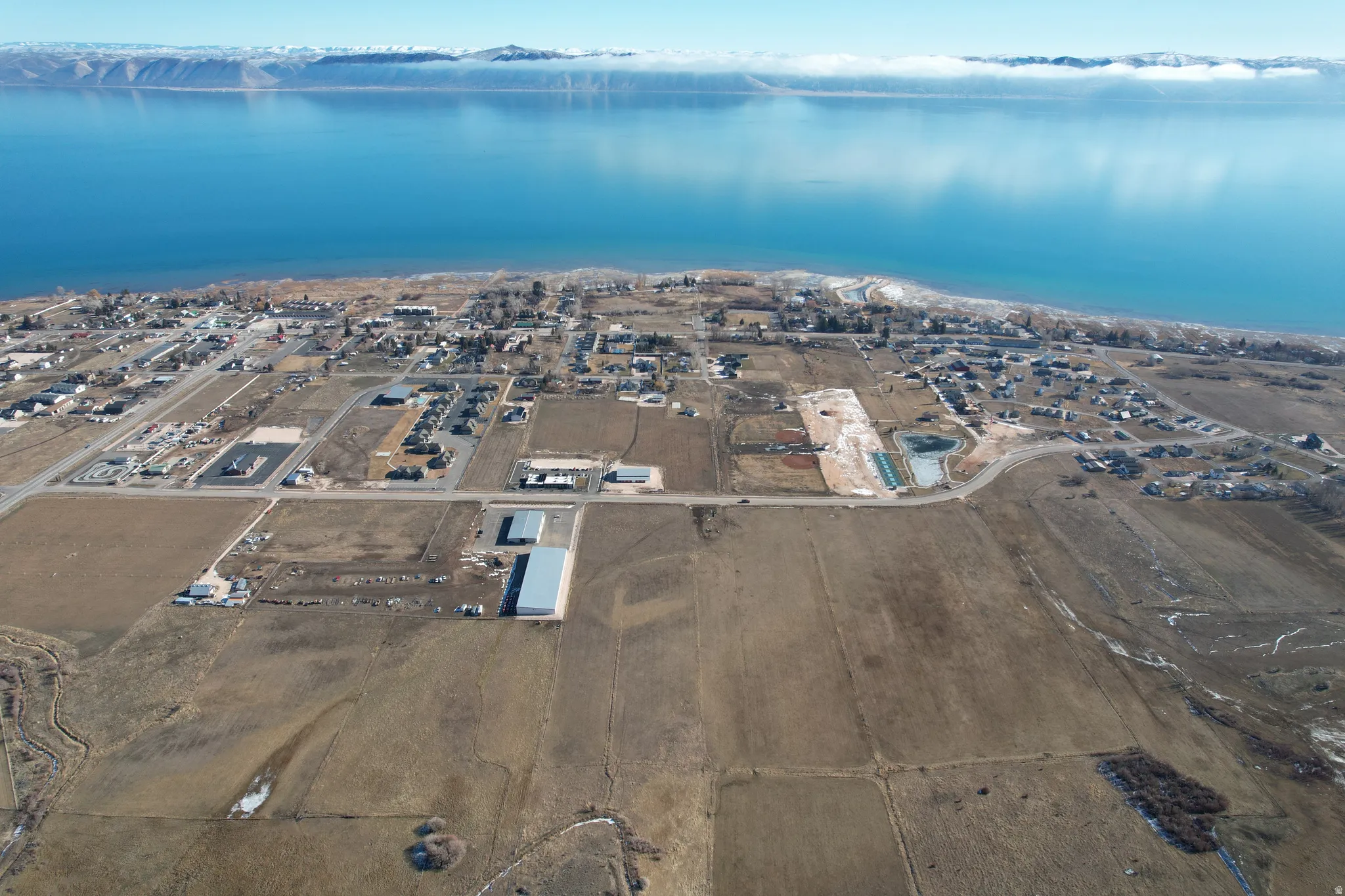 Aerial overview of property's location featuring a large body of water and nearby suburban area