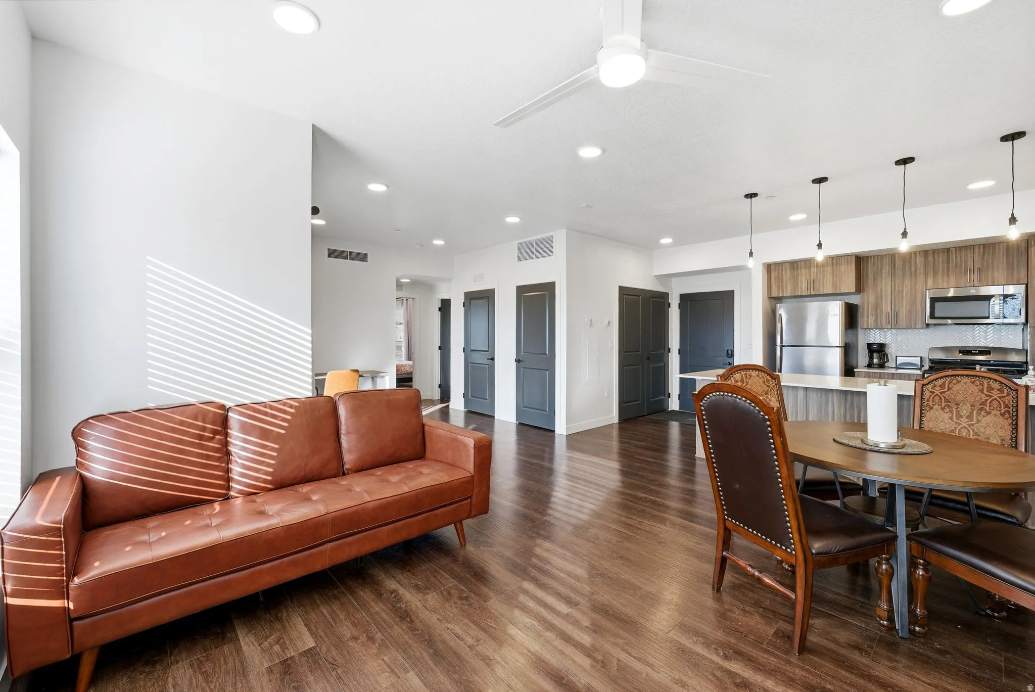 Dining area with dark wood-type flooring, a ceiling fan, and recessed lighting