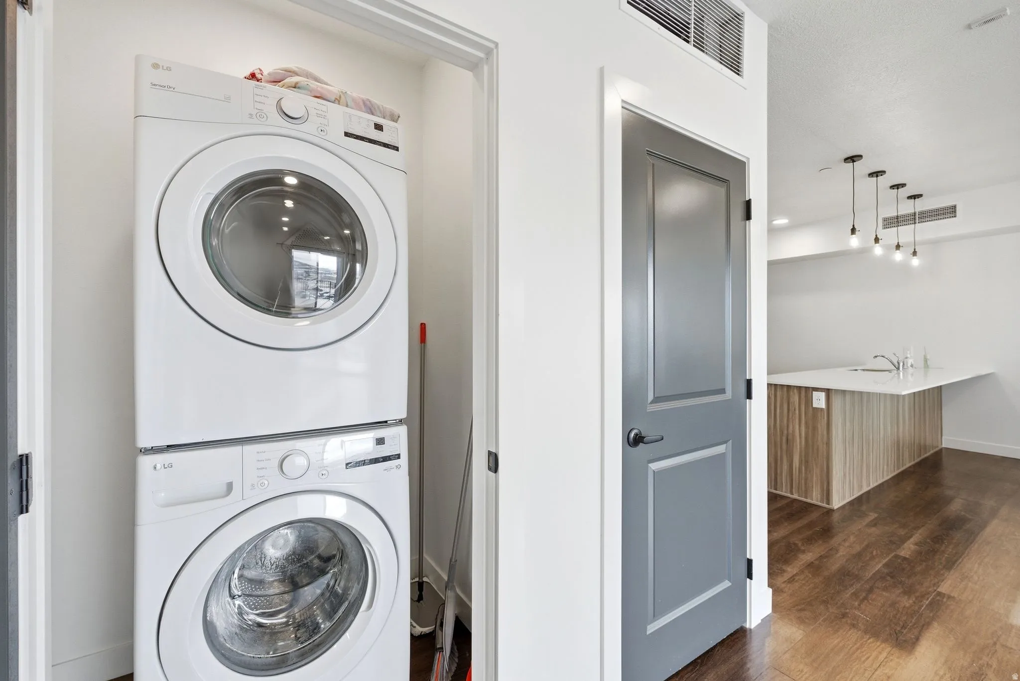 Washroom featuring estacked washer and dryer and dark wood-style flooring