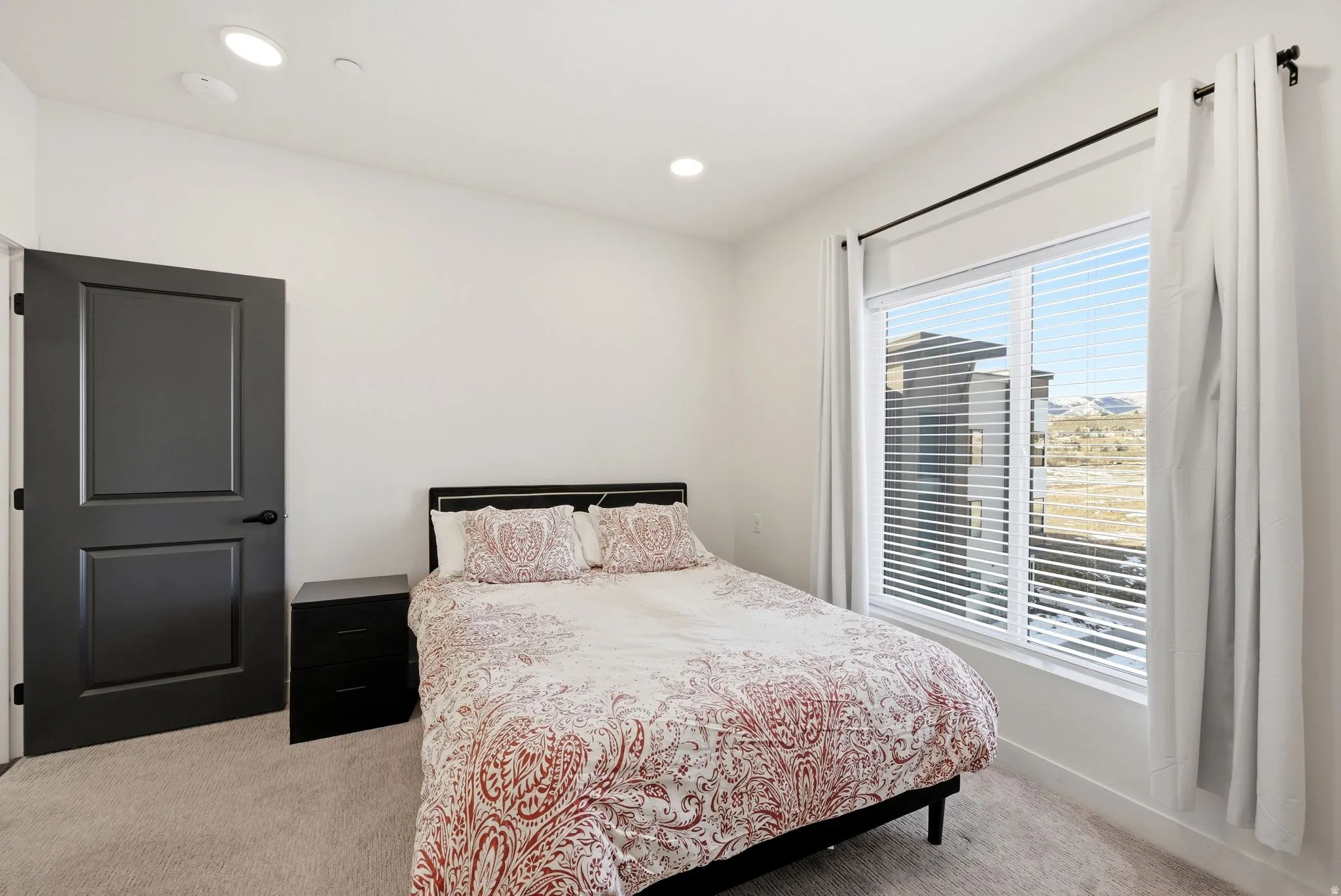 Bedroom with light colored carpet and recessed lighting