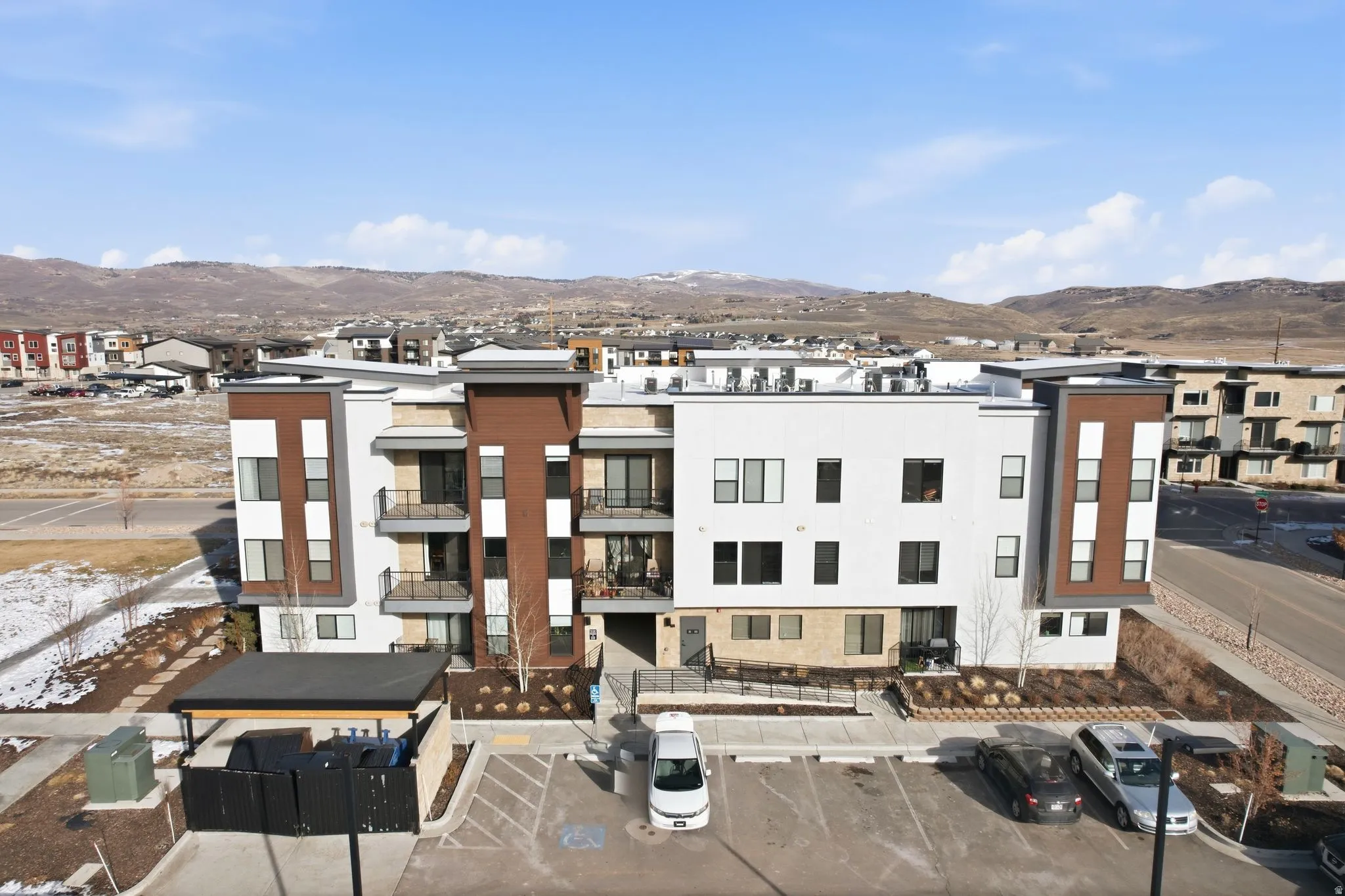 View of building exterior with a mountain view and uncovered parking